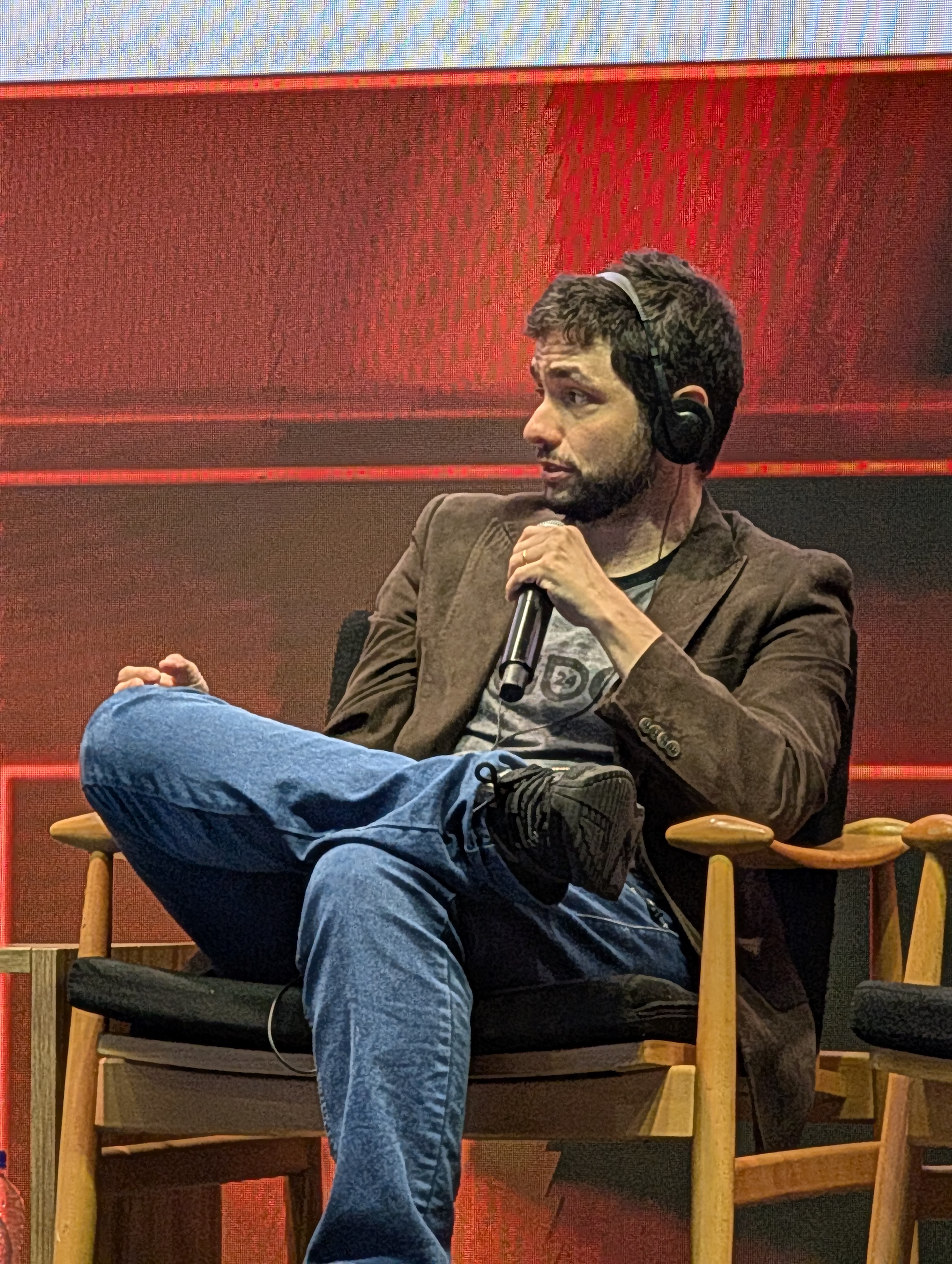 Luís Daher speaking on stage during an industry panel